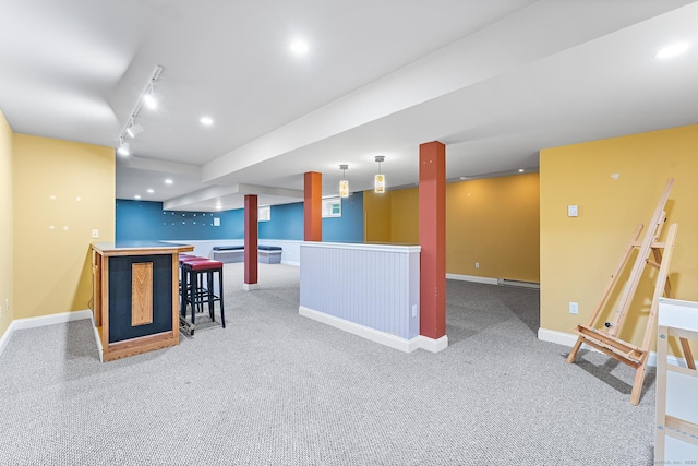 kitchen with carpet floors, baseboards, track lighting, and hanging light fixtures