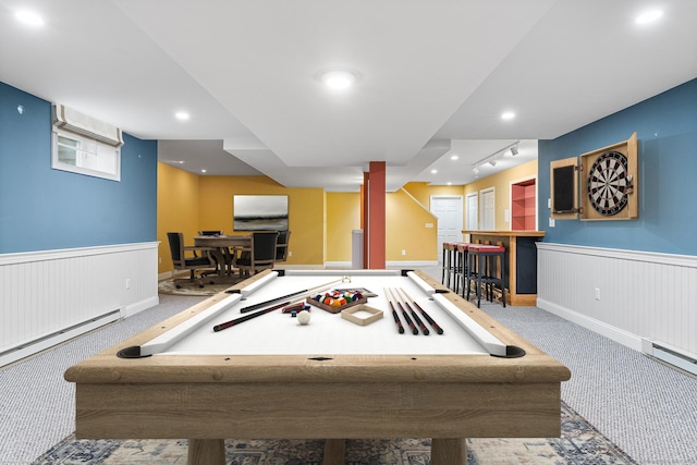 playroom with carpet, a wainscoted wall, rail lighting, a bar, and baseboards