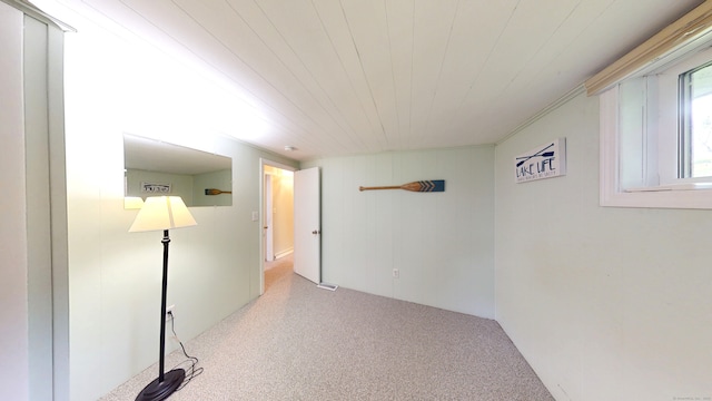 carpeted spare room with wood ceiling
