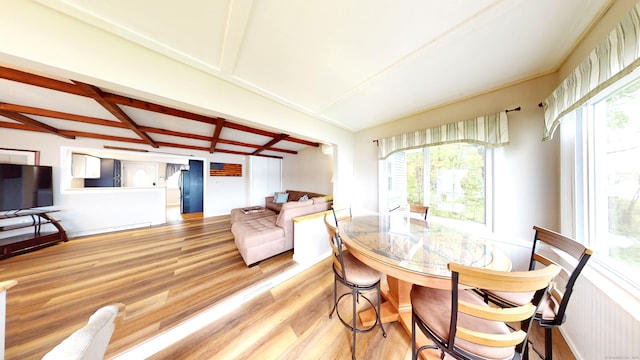 dining room featuring healthy amount of natural light, wood finished floors, beam ceiling, and coffered ceiling