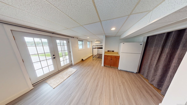doorway featuring light wood-style floors, french doors, baseboards, recessed lighting, and a paneled ceiling