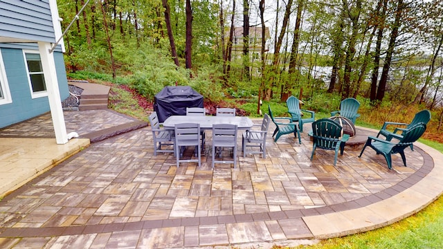 view of patio / terrace featuring outdoor dining space, grilling area, and a fire pit