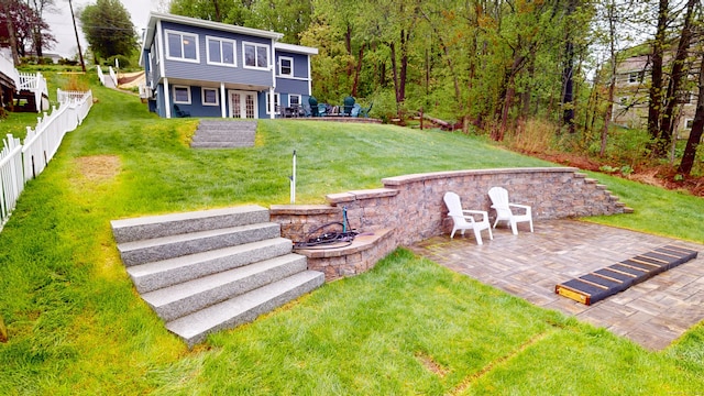 view of yard with a patio area, french doors, and a view of trees