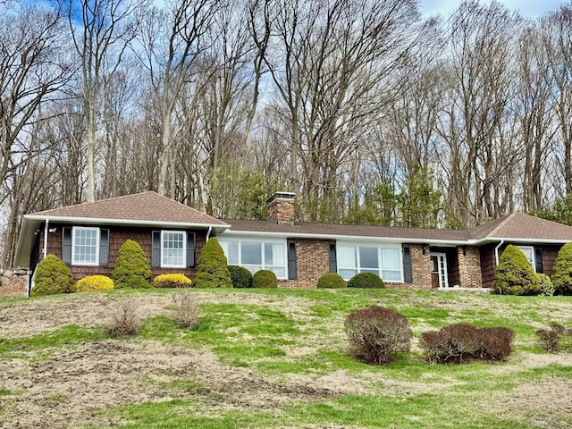 single story home with a chimney and a front lawn