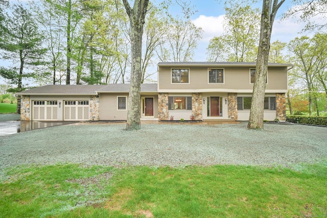view of front facade with stone siding, driveway, and a garage