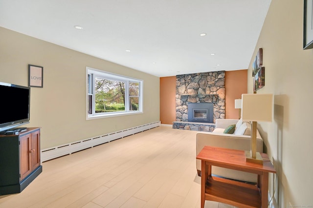 living room with baseboard heating, a stone fireplace, light wood-style floors, and recessed lighting