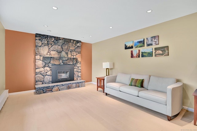 living room featuring baseboards, a fireplace, and recessed lighting
