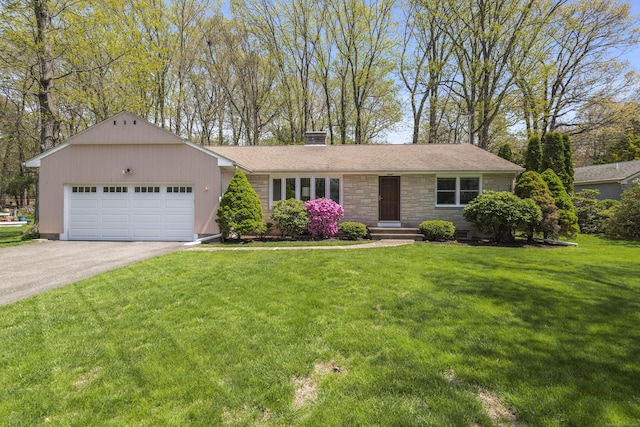 ranch-style house featuring an attached garage, driveway, a front lawn, a chimney, and stone siding