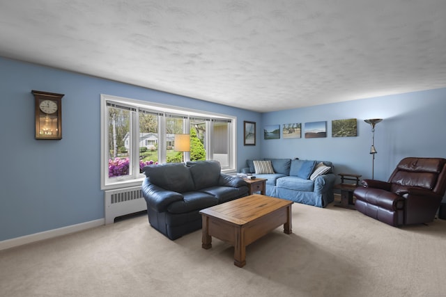 living room featuring radiator heating unit, light carpet, baseboards, and a textured ceiling