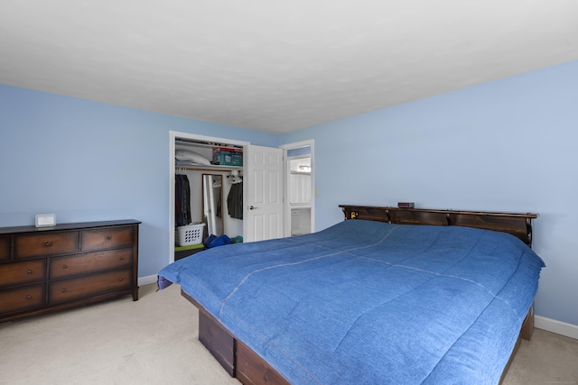 bedroom with light colored carpet, baseboards, and a closet