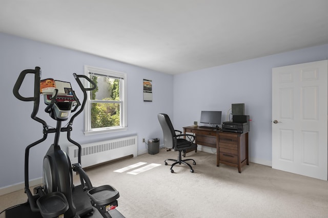 carpeted office with radiator heating unit and baseboards