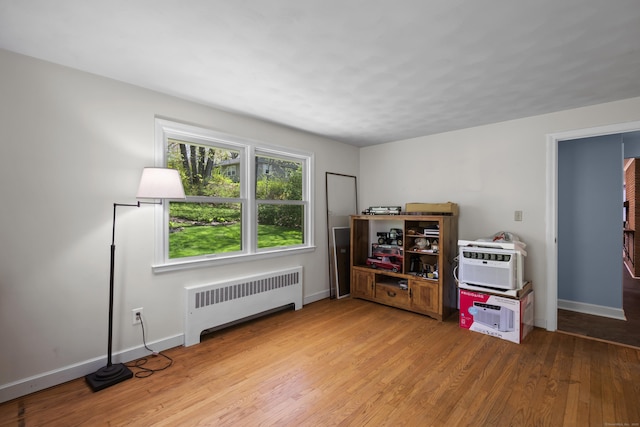 miscellaneous room featuring radiator, light wood-style flooring, and baseboards