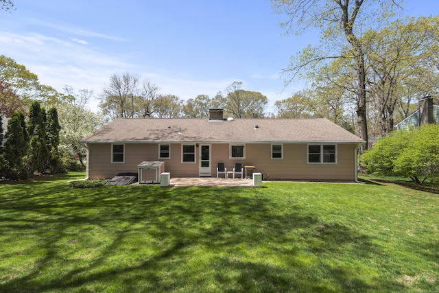 back of house with a chimney, a patio area, and a yard