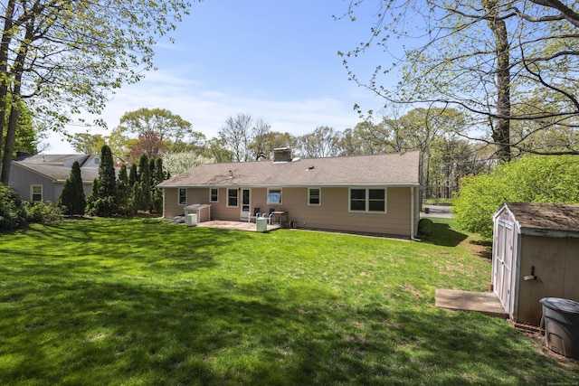 back of house with a storage shed, a lawn, an outdoor structure, and a wooden deck