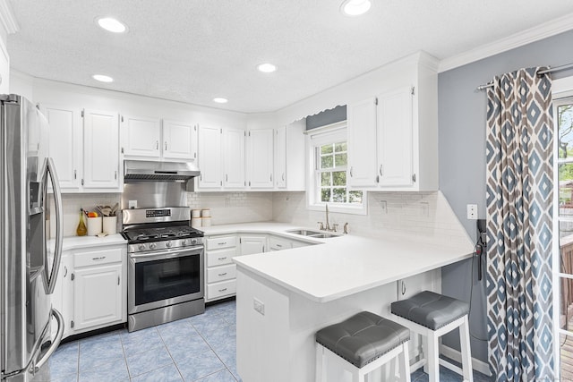 kitchen featuring stainless steel appliances, extractor fan, a peninsula, a sink, and white cabinetry