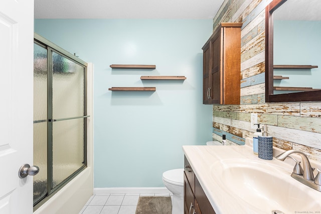 full bath featuring toilet, tile patterned floors, shower / bath combination with glass door, vanity, and backsplash