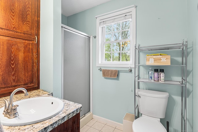 bathroom with a shower stall, tile patterned flooring, toilet, baseboards, and vanity