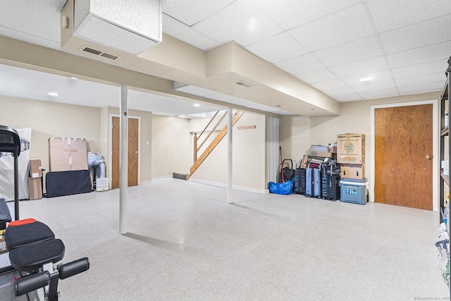 finished below grade area featuring stairs, tile patterned floors, and baseboards