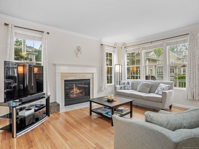 living area with hardwood / wood-style floors, a premium fireplace, healthy amount of natural light, and crown molding