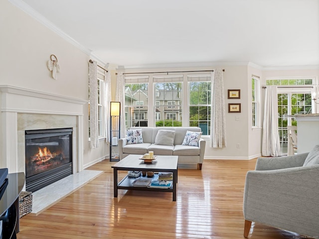 living room with ornamental molding, plenty of natural light, and light wood-style floors