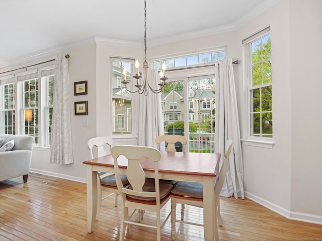 dining space featuring baseboards, light wood-style floors, ornamental molding, and a chandelier