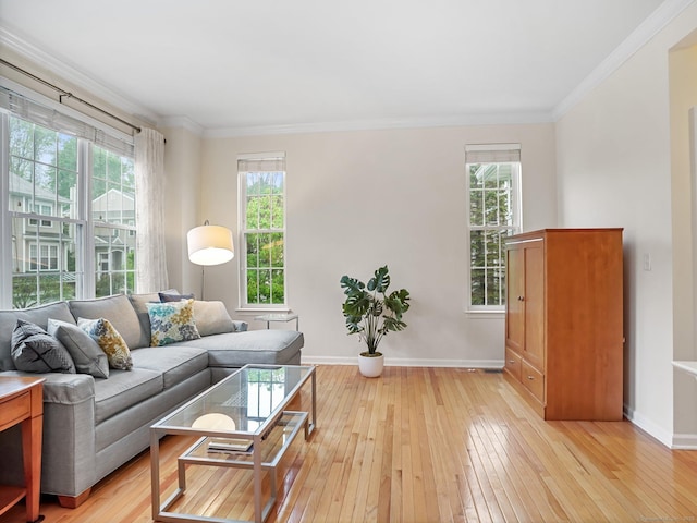 living room featuring baseboards, light wood-style floors, crown molding, and healthy amount of natural light