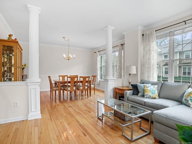 living room featuring ornate columns, plenty of natural light, and crown molding
