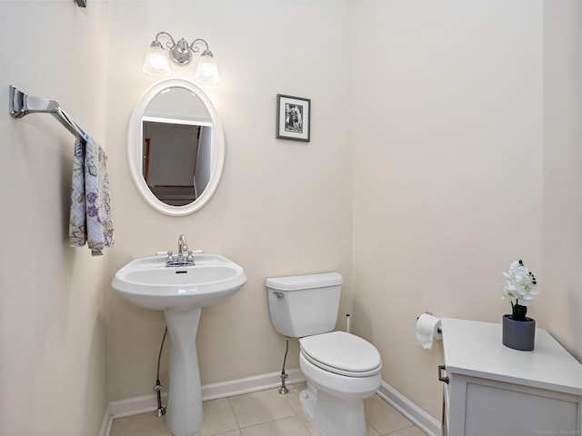 bathroom featuring tile patterned floors, toilet, baseboards, and a sink