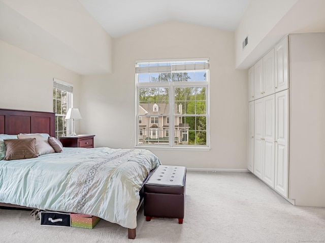 bedroom featuring light carpet, vaulted ceiling, and baseboards