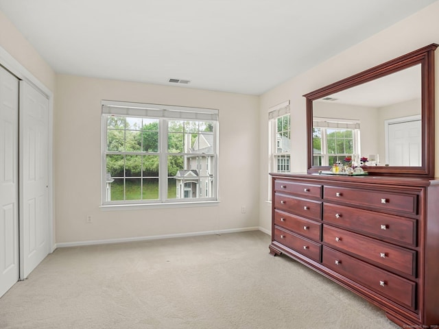 bedroom with light colored carpet, baseboards, and a closet