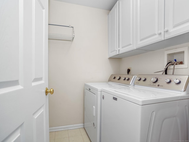 laundry area with cabinet space, washing machine and dryer, light tile patterned floors, and baseboards