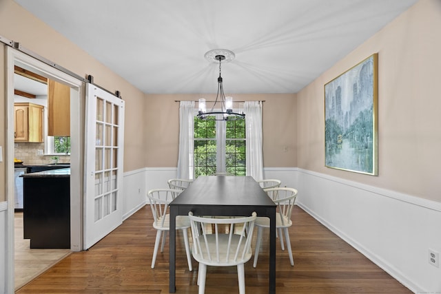 37 Hungry Hill Cir, Guilford, CT 06437 - dining area with a chandelier, wood finished floors, a wainscoted wall, and a barn door