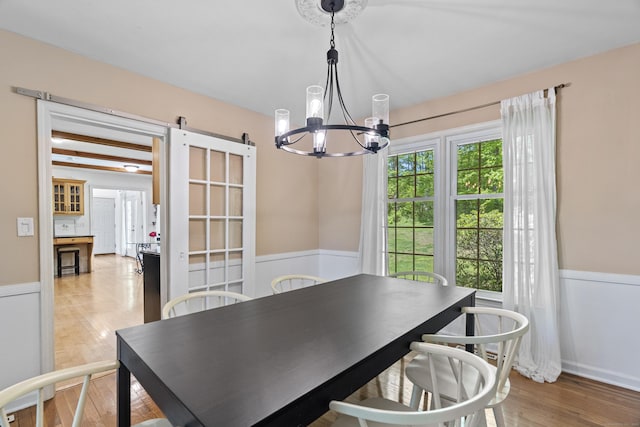 37 Hungry Hill Cir, Guilford, CT 06437 - dining area with a chandelier, a barn door, wainscoting, and light wood-type flooring