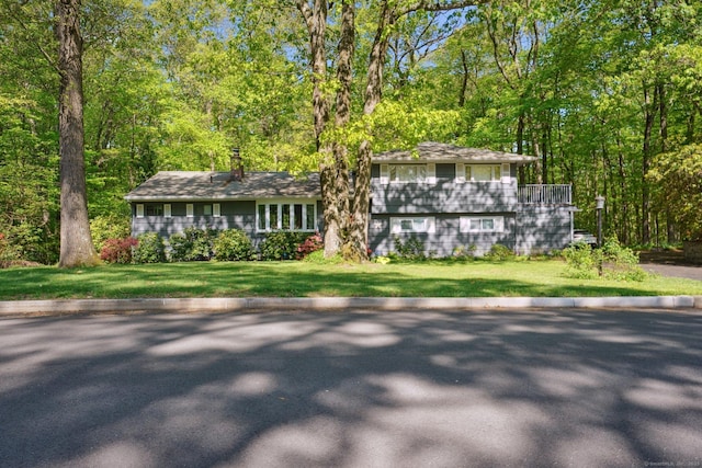 14 Live Oak Rd, Norwalk, CT 06851 - view of front facade with a front lawn, a chimney, and a balcony