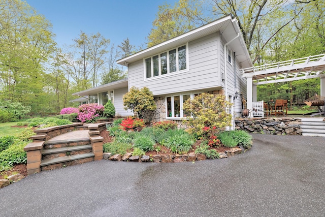 split level home with a patio and stone siding