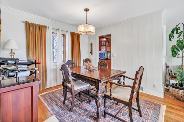 dining area featuring crown molding and light wood-style flooring