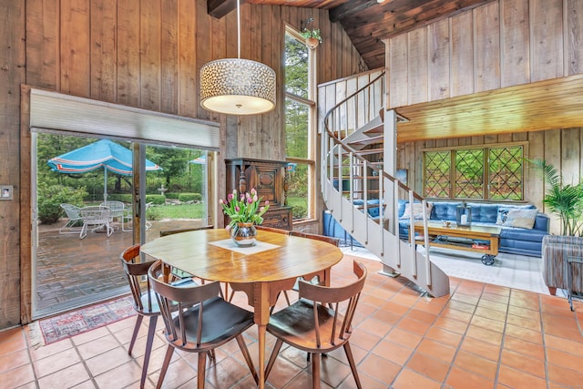 tiled dining room with wooden walls, stairway, wood ceiling, high vaulted ceiling, and beamed ceiling