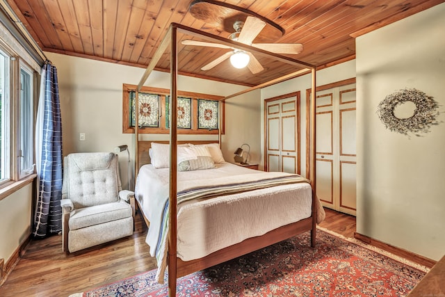 bedroom with wooden ceiling, wood finished floors, baseboards, and a ceiling fan