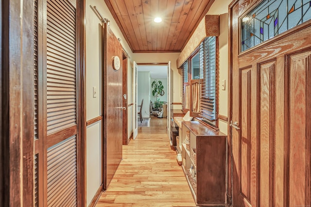 hall featuring light wood-style flooring, recessed lighting, and wood ceiling