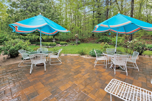 view of patio / terrace featuring outdoor dining area and view of scattered trees