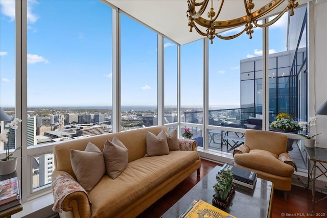 sunroom / solarium featuring a chandelier, a city view, and plenty of natural light