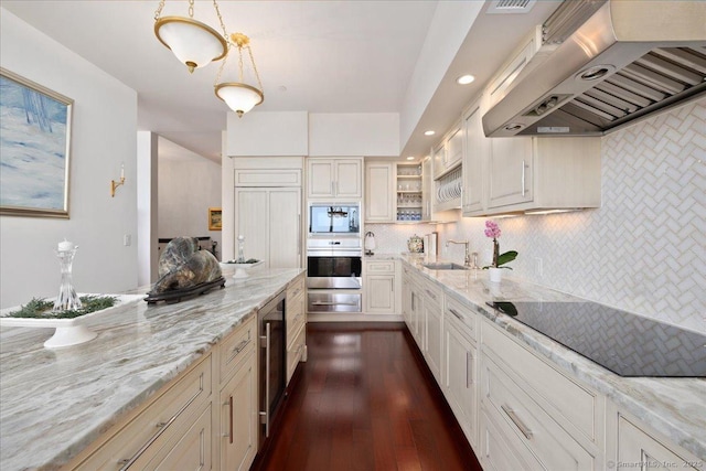 kitchen with range hood, black electric cooktop, beverage cooler, a sink, and light stone countertops