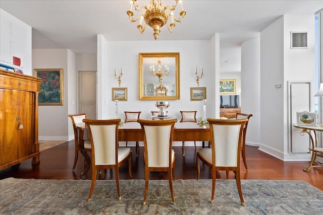 dining area featuring a chandelier, baseboards, and wood finished floors