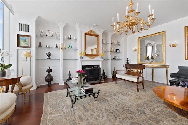 living area featuring wood finished floors, built in features, a chandelier, and a fireplace with flush hearth
