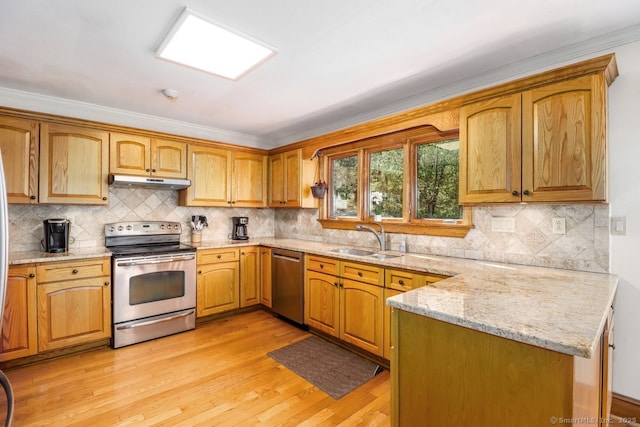 kitchen featuring light wood finished floors, a sink, stainless steel appliances, under cabinet range hood, and light stone counters