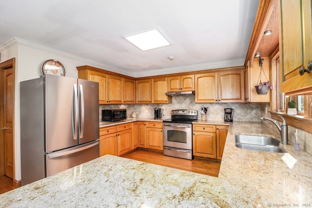 kitchen with appliances with stainless steel finishes, light stone countertops, ornamental molding, and a sink