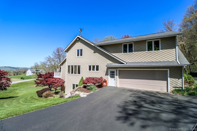 view of front facade with a front yard, an attached garage, and driveway