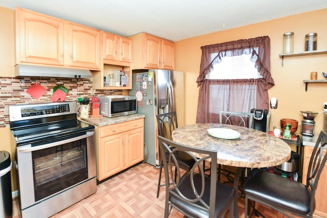 61 Kenyon Cir, New Britain, CT 06053 - kitchen with light brown cabinetry, under cabinet range hood, decorative backsplash, light countertops, and appliances with stainless steel finishes