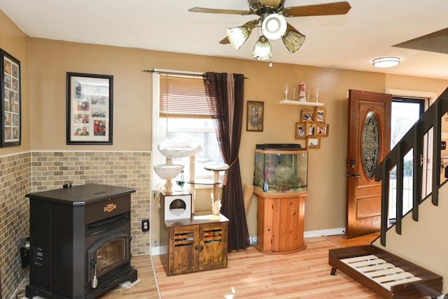 61 Kenyon Cir, New Britain, CT 06053 - sitting room with a ceiling fan, stairs, a wood stove, and wood finished floors