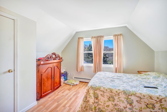 bedroom featuring light wood finished floors, baseboard heating, and vaulted ceiling